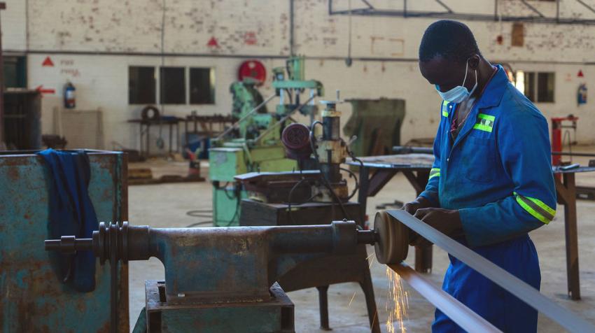 Un homme devant une machine travaille dans une usine d’assemblage.