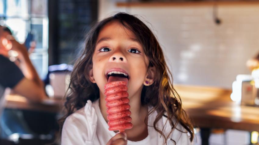 Young girl licking an ice block