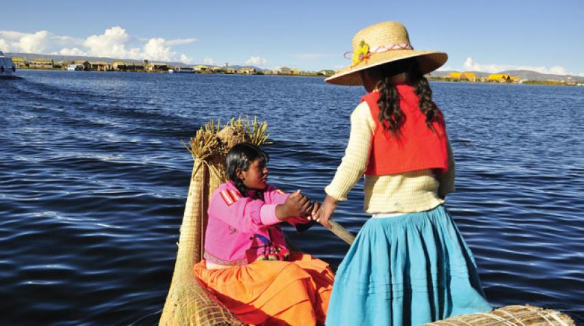 Deux jeunes femmes sur le lac Titicaca, l'étendue d'eau la plus élevée du monde, ouvert à la navigation commerciale, Puno, près des îles Uros, au Pérou.