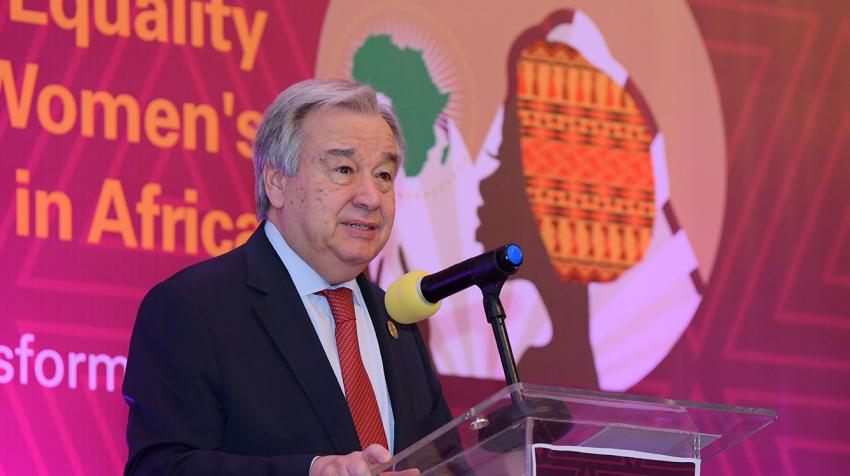 Secretary-General António Guterres at a podium with poster on African women's empowerment behind him