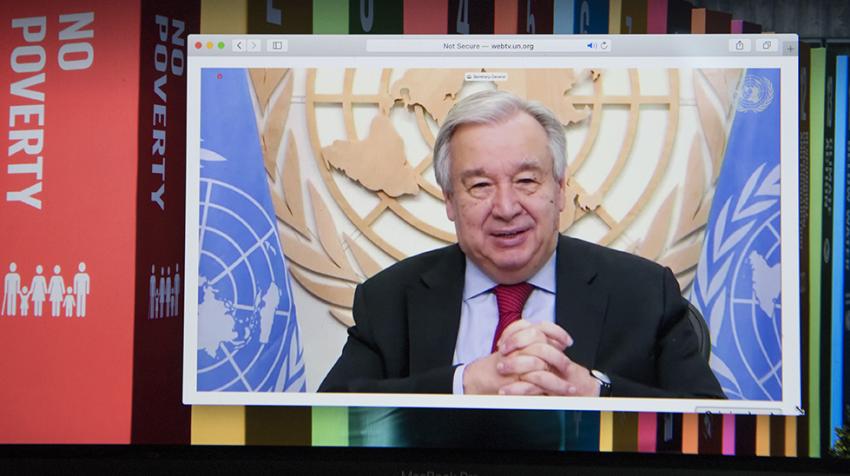 Secretary-General António Guterres on screen with background of SDGs