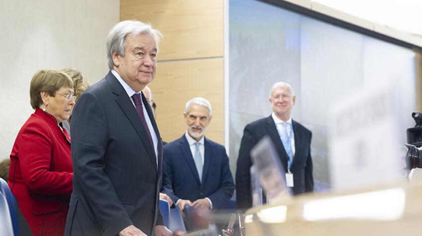 El Secretario General António Guterres de pie en el podio junto con otros funcionarios de la ONU.