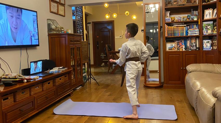 A child doing Karate in front of the TV