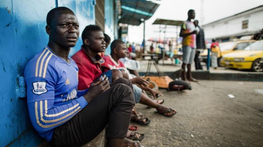Unemployed taxi drivers sit on curb