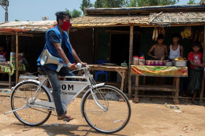 A cyclist rides through a refugee camp