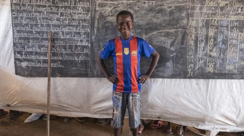 A young boy stands in front of the blackboard in a classroom at the peacekeeping site in Kago Bandoro, Central African Republic,