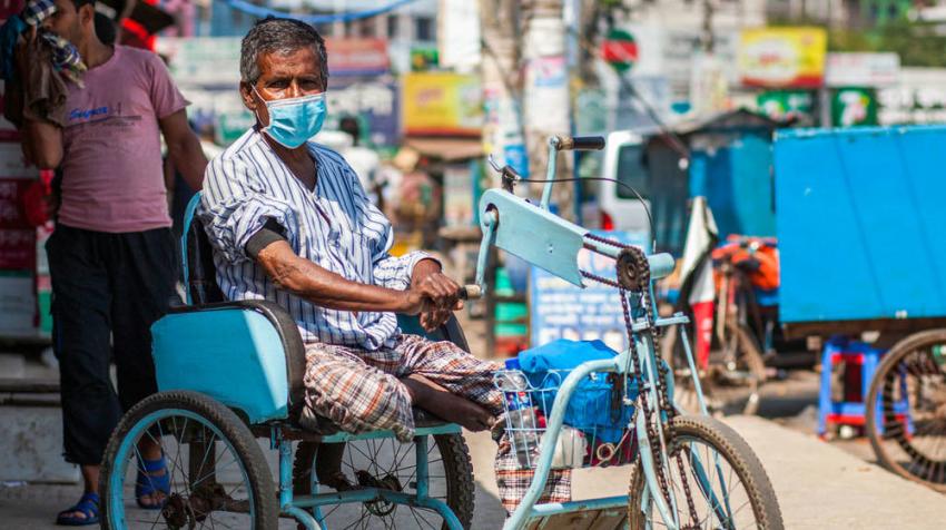 Un homme en fauteuil roulant dans une rue, au Bangladesh, pays qui risque d'etre fortement touche par les retombees economiques de la COVID-19.