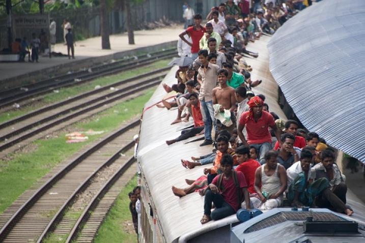 People in Bangladesh traveling dangerously on the roof of a train.