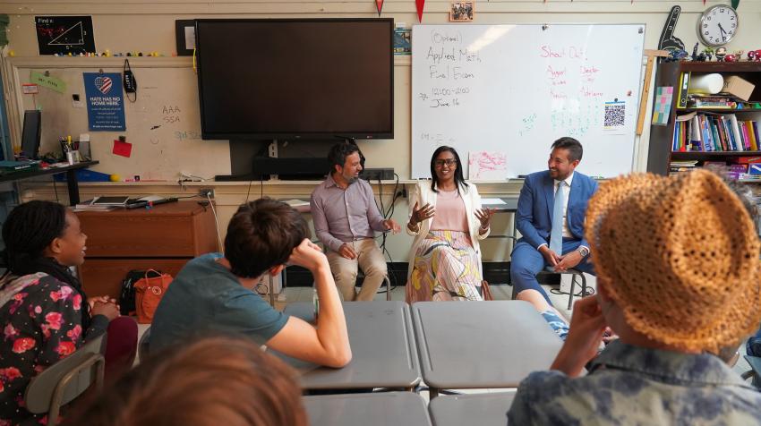 Un officials speak to students in a classroom.