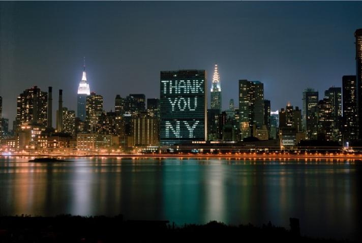 UN Secretariat building with windows illuminated with the words "thank you NY'.