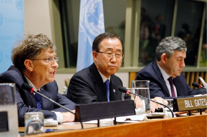 Bill Gates speaks to the press with Ban Ki-moon and Gordon Brown to the right.