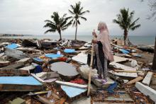 A woman stands on collapsed structures in Mamboro fishing village, Central Sulawesi, Indonesia, following the 2018 earthquake and tsunami there. Photo: OCHA/Anthony Burke