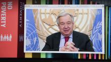 Secretary-General António Guterres on screen with background of SDGs