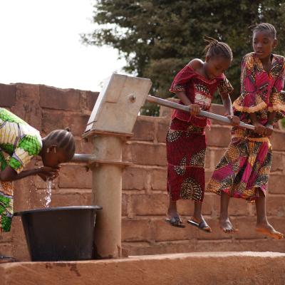 Young girls pumping water at a public borehole in West Africa. Riccardo Niels Mayer/Adobe Stock