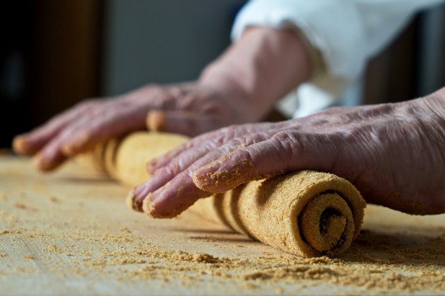 closeup of hands rolling dough