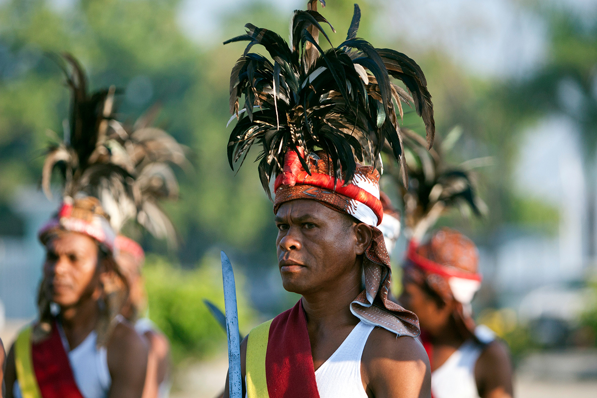 Men wearing traditional head pieces line up