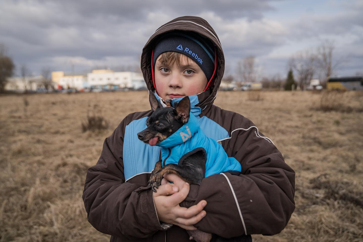 Portrait of a boy holding a small dog.