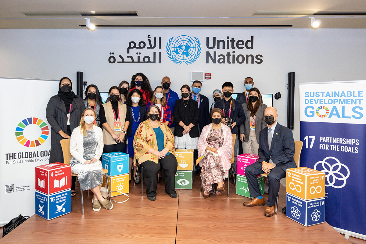 UN officials pose in front of SDG posters