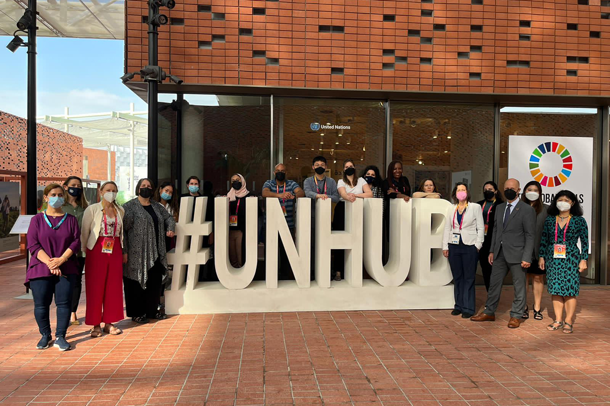 UN officials pose in front of an installation that readds #UNHUB