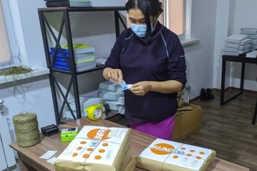Une femme prépare des enveloppes de l'UNFPA.