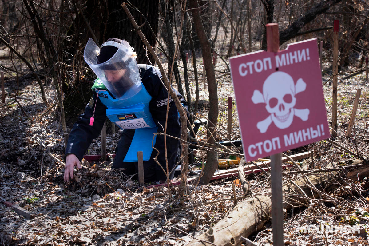 a person works on deactivating a landmine