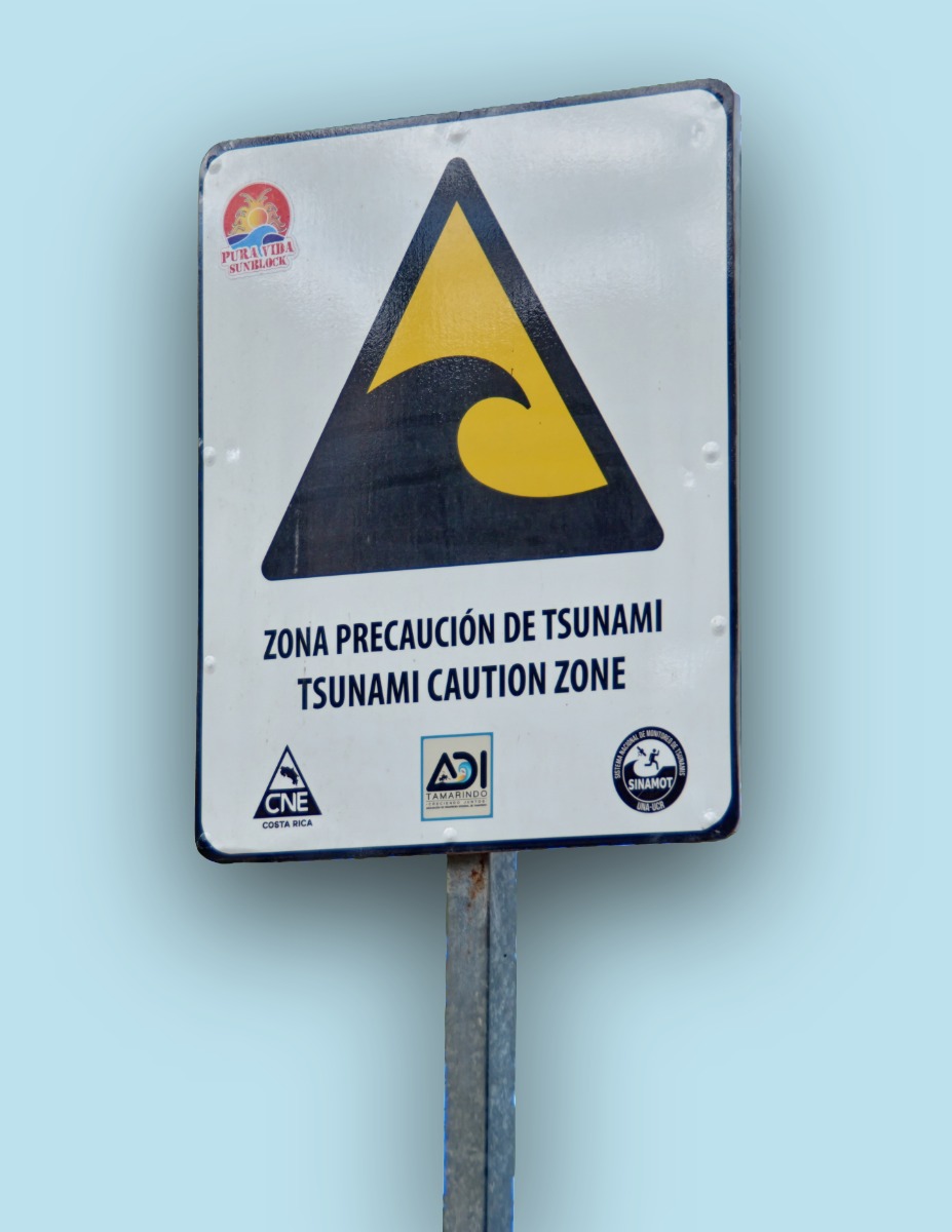 Señal de precaución ante el riesgo de sunami escrita en español e inglés