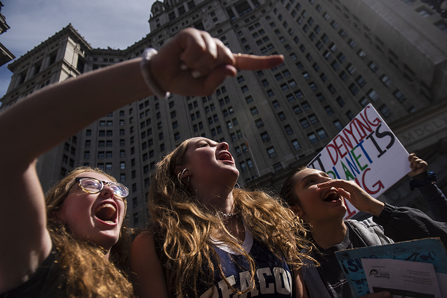 Girls holding signs up and shouting.