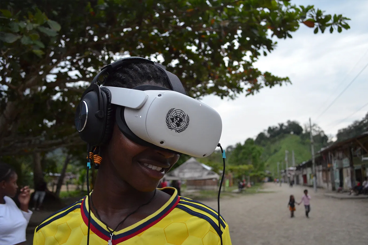 A photograph showing a young person wearing a virtual-reality headset and smiling