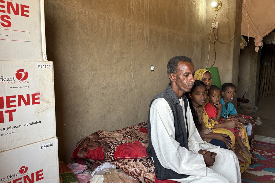 A family of internally displaced people, father, mother and their three children, sitting on a makeshift bed. WFP