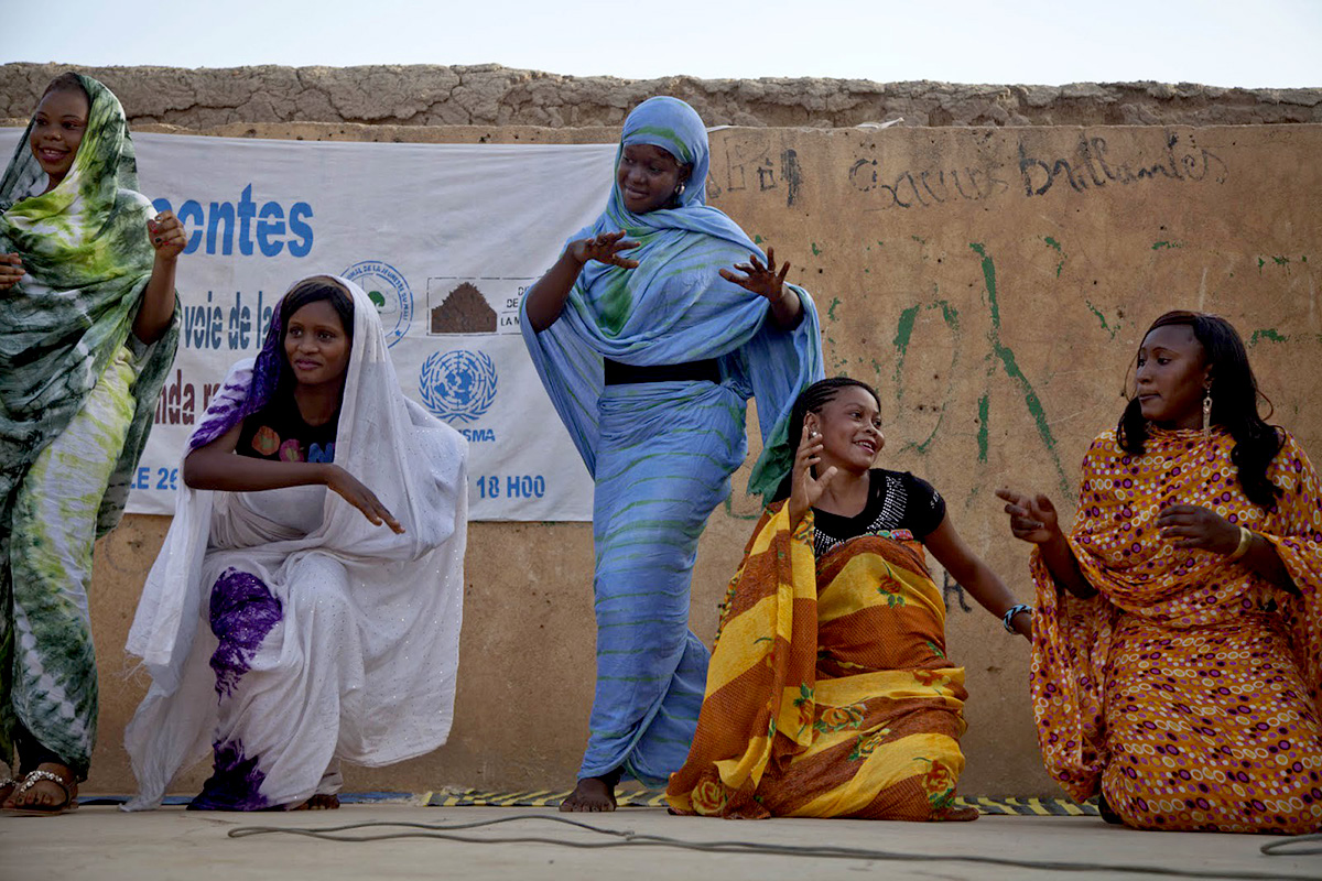 A group of girls perform on an outdoor stage.