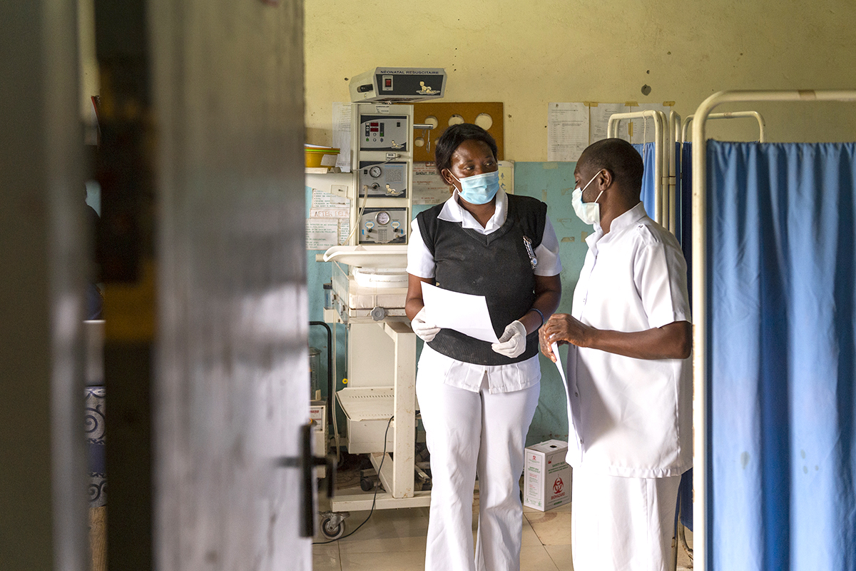 Two nurses stand in an examination room.