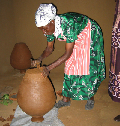 Mujer fabricando tinaja para almacenamiento de agua