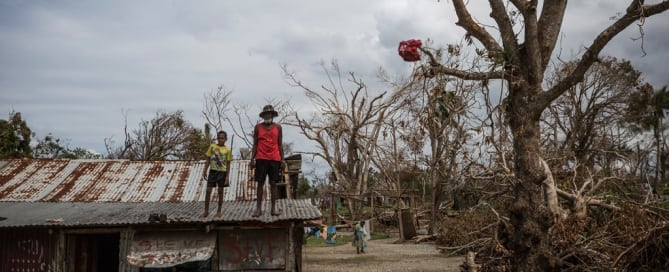 A child and an elderly man stand on the roof of a building damaged when Cyclone Pam hit Vanuatu in March 2015. Photo: UNICEF/Vlad Sokhin