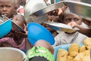 Photo: Children at an IDP camp in Kitchanga, North Kivu, DRC, await their meal and the Secretary-General.