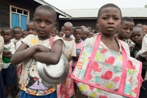 Photo: Children at an IDP camp in Kitchanga, North Kivu, DRC, await their meal and the Secretary-General.