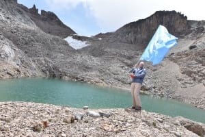 Photo: UN staffer Bo Sorensen waves the UN flag near a receded glacier on Mount Kenya.