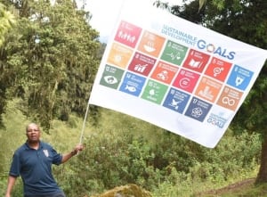 Photo: UN staffer Newton Kanhema waves the SDG flag on Mount Kenya.