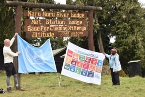 Photo: UN staffer Newton Kanhema and a guide wave the SDG and UN flag on Mount Kenya.
