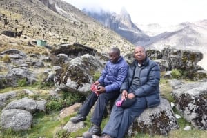 Photo: UN staffers Newton Kanhema and Bo Sorensen take a break from their strenuous hike on Mount Kenya.