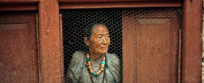 Photo: An old woman at her window in a Nepalese village. UN Photo/John Isaac