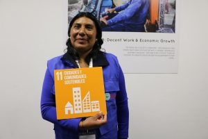 Photo: An Ecuadorian woman holds the Goal 11 Sustainable Cities icon.