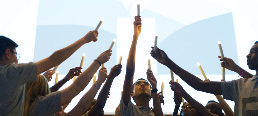 A group of people holding candles up in the air