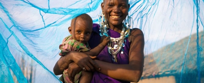 Una madre con su hijo bajo una mosquitera tratada con insecticida en Arusha, Tanzania. Foto: UNICEF/Hallahan
