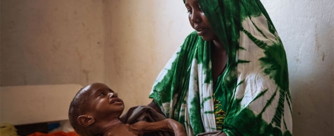 Una madre espera en el hospital general de Kismayo (Somalia) a que atiendan a su hijo de dos años que sufre desnutrición. Foto: OIM/Muse Mohammed
