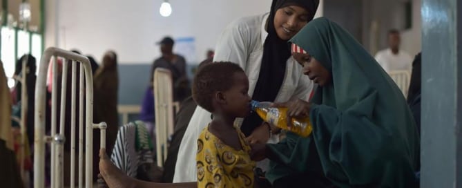 Una madre da una bebida con sales rehidratantes a su hija en un hospital de Mogadishu en Somalia. Foto: ONU/Tobin Jones