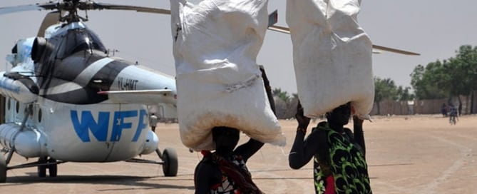 Unas mujeres llevan bolsas de comidas entregadas por la ONU en Sudán del Sur. Foto: OCHA/Gemma Connell
