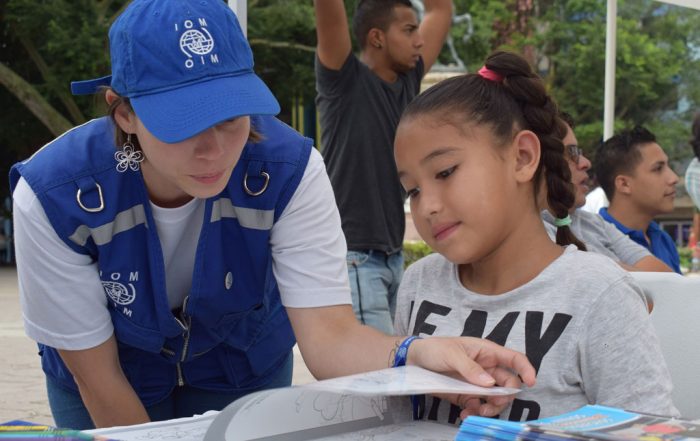 Una trabajadora de la OIM en Honduras informa a esta niña sobre los derechos de los migrantes retornados. Foto: OIM Honduras