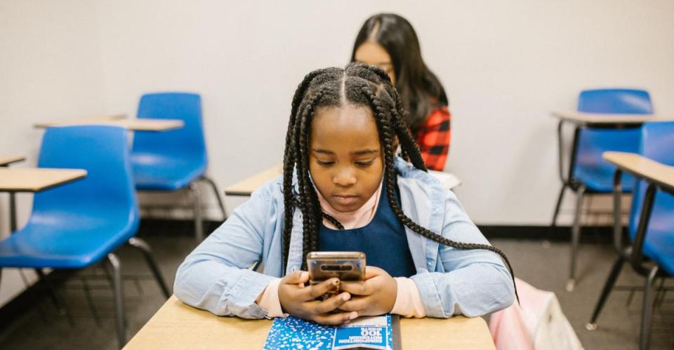  Niña de la escuela con teléfono móvil