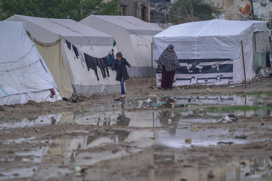 In the photo: displaced people in makeshift camp. With no infrastructure like running water, sewage, or electricity, the winter rains flood improvised camps like this leaving people struggling with cold, mud and illness.