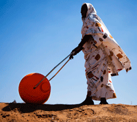 A woman in El Fasher, North Darfur, uses a Water Roller for easily and efficiently carrying water. UN Photo/Albert Gonzalez Farran